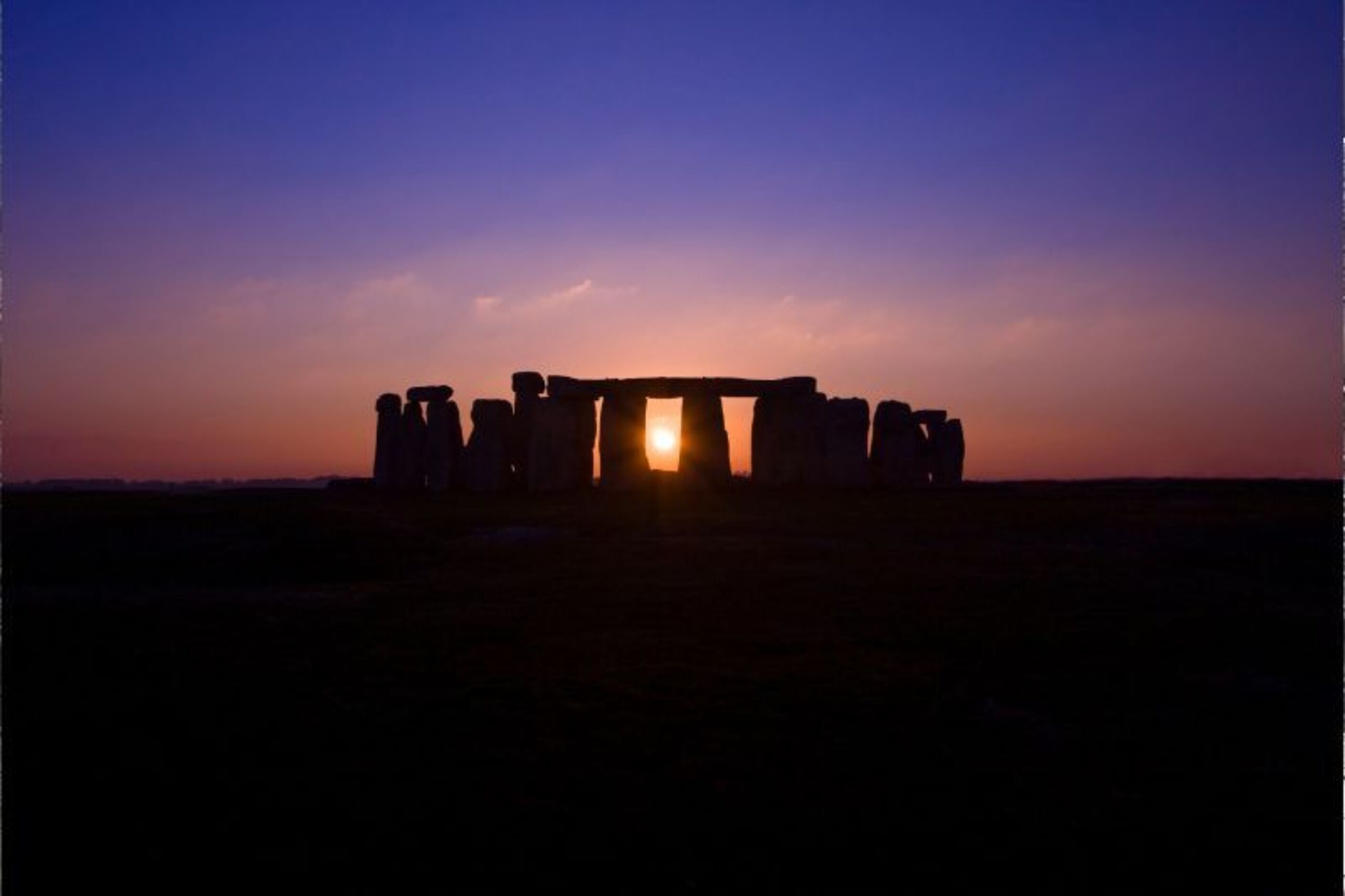Stonehenge at sunset with the sun centered directly in the middle center stone